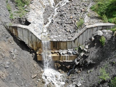 2 Torrente Moscardo (Paluzza), briglia in calcestruzzo del 2015, già compromessa sia dal cedimento della sponda destra, sia dalla totale esposizione della fondazione