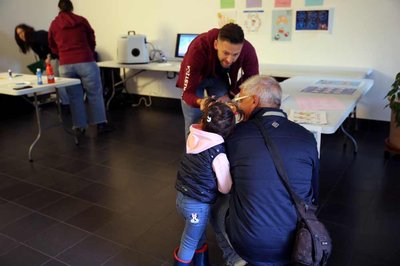 Adulti e bambini in visita agli stand di Collega-menti